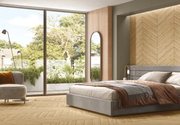 Chevron wooden tiles across a bedroom floor and feature wall